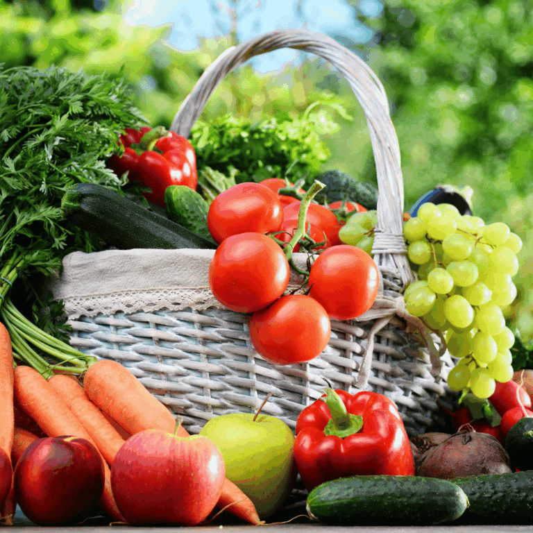 Esta imagen muestra una cesta blanca llena de frutas y verduras frescas